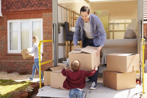 Removal team pricing a move in Holland Park with packed boxes and furniture